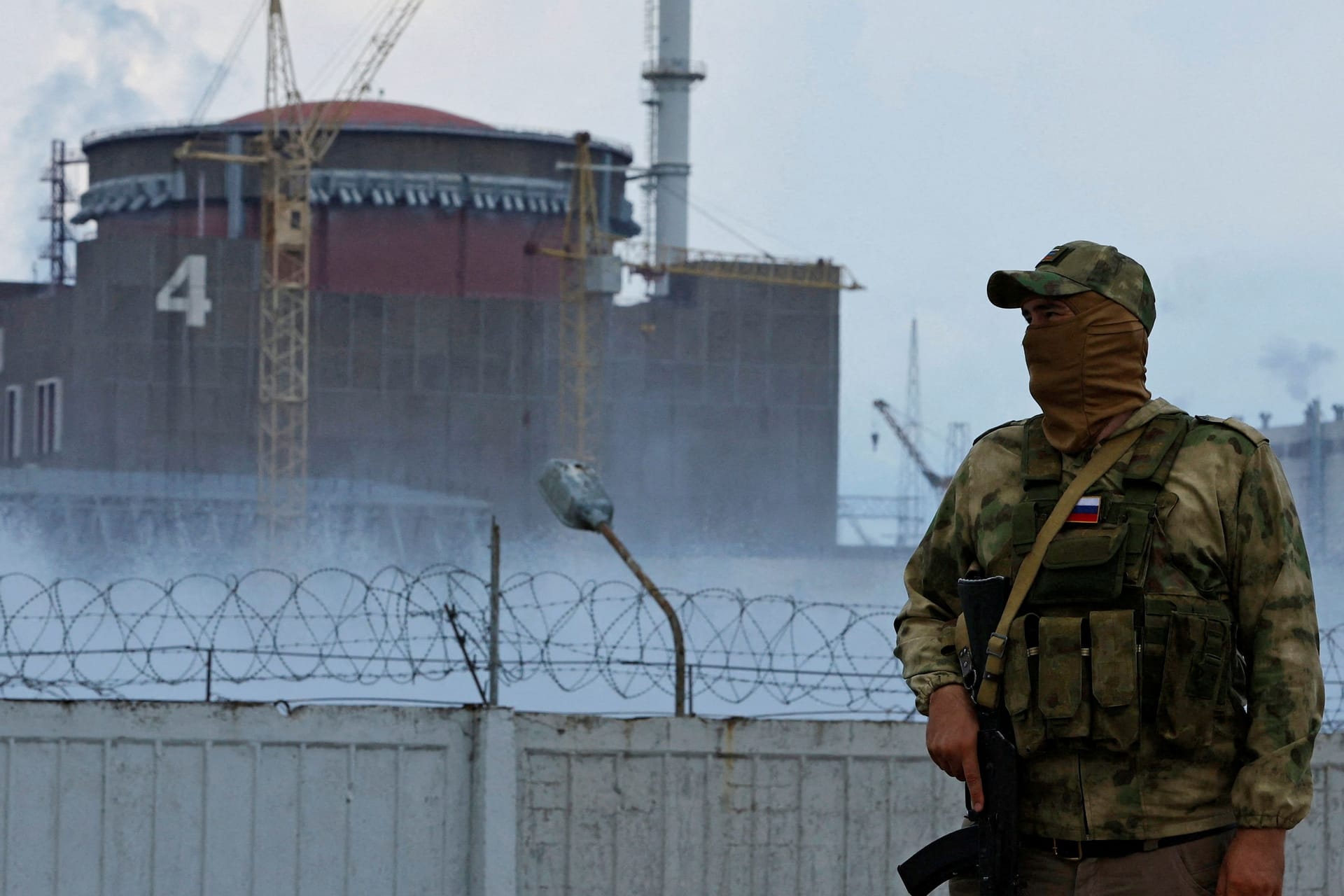 FILE PHOTO: A serviceman with a Russian flag on his uniform stands guard near the Zaporizhzhia Nuclear Power Plant in the course of Ukraine-Russia conflict outside the Russian-controlled city of Enerhodar in the Zaporizhzhia region, Ukraine August 4, 2022.