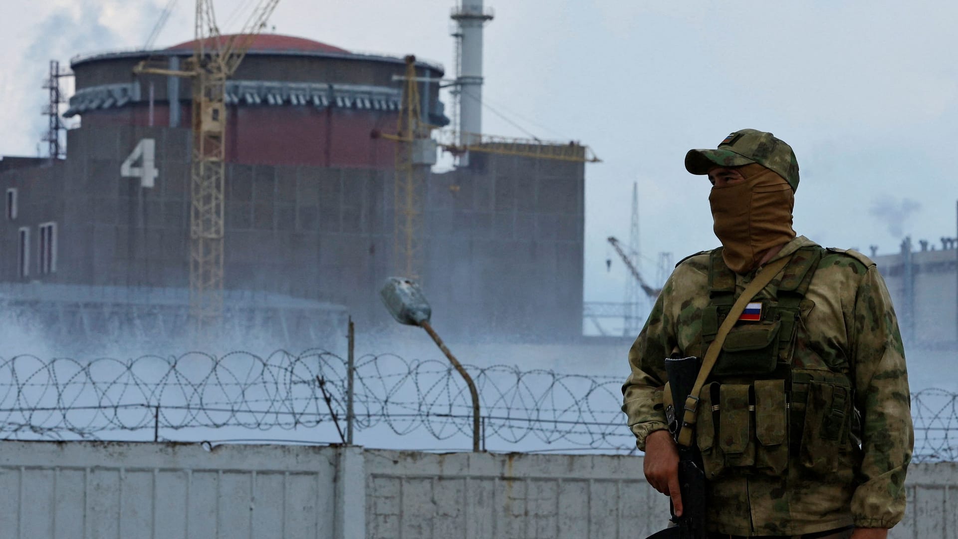 FILE PHOTO: A serviceman with a Russian flag on his uniform stands guard near the Zaporizhzhia Nuclear Power Plant in the course of Ukraine-Russia conflict outside the Russian-controlled city of Enerhodar in the Zaporizhzhia region, Ukraine August 4, 2022.