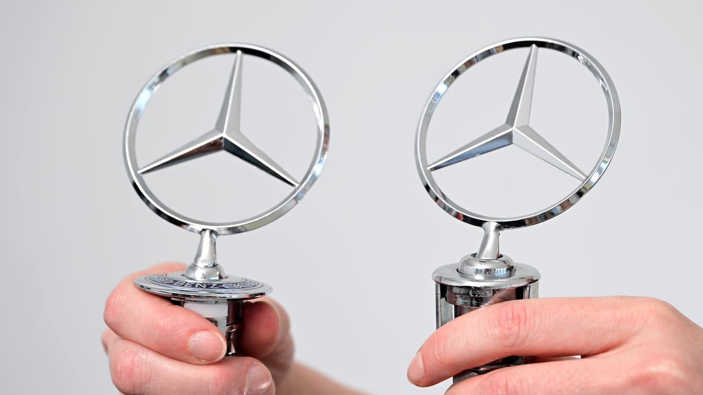 Schwer erkennbare Fälschungen: Ein Original Mercedes-Benz Stern (l) und eine Fälschung (r) werden in einem Büro des Fahrzeugherstellers Mercedes-Benz von zwei Händen gehalten.