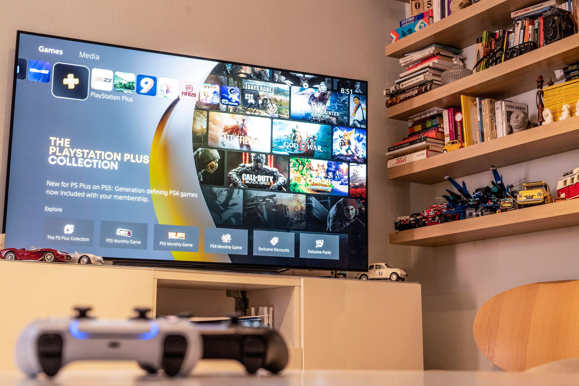 Fernseher zeigt "Playstation Plus" und auf dem Tisch liegt der Playstation-Controller.