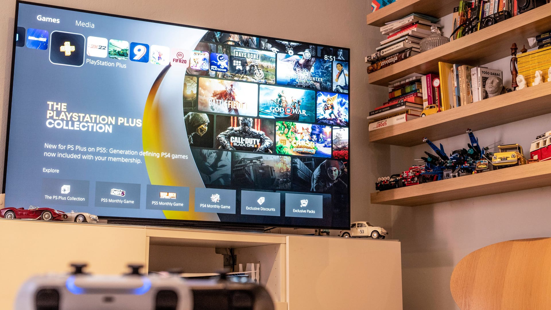 Fernseher zeigt "Playstation Plus" und auf dem Tisch liegt der Playstation-Controller.