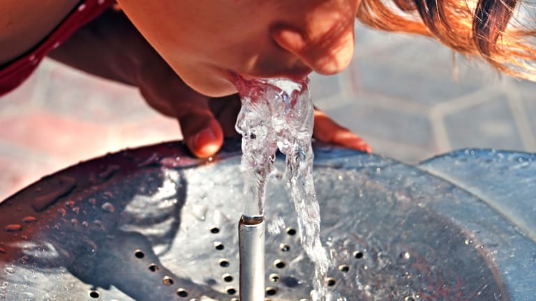 Ein kind erfrischt sich an einem Trinkbrunnen (Symbolbild): Überall in Deutschland sollen bald die kostenlosen Durstlöscher stehen.