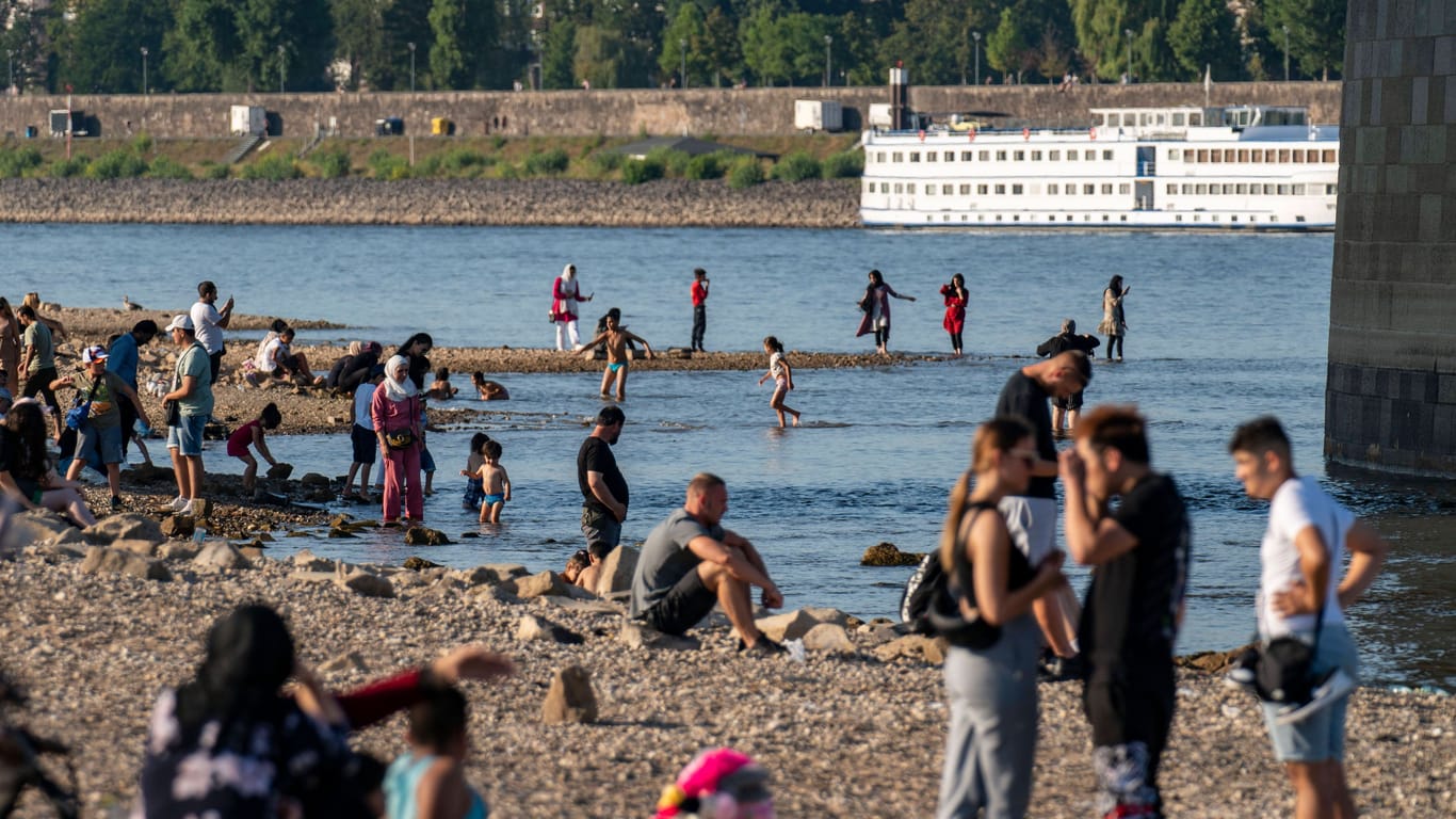 Menschen suchen Abkühlung am Rheinufer (Archivbild): Am Donnerstag werden wieder weit über 30 Grad erwartet.