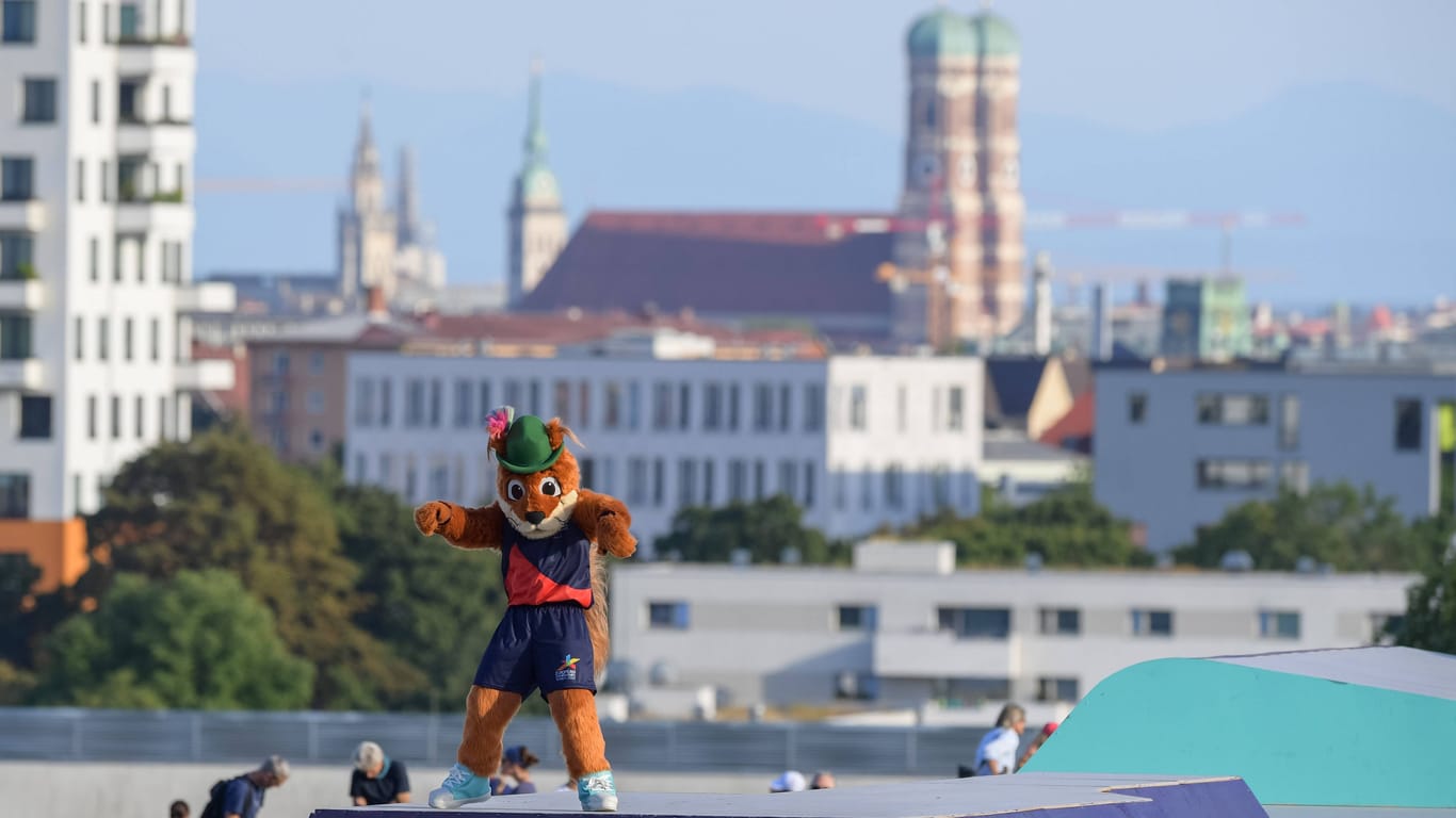 Olympiaberg in München, im Hintergrund die Frauenkirche: Im Vordergrund das Maskottchen der EM, das Eichhörnchen "Gfrei Di!", also "Freu' Dich!"