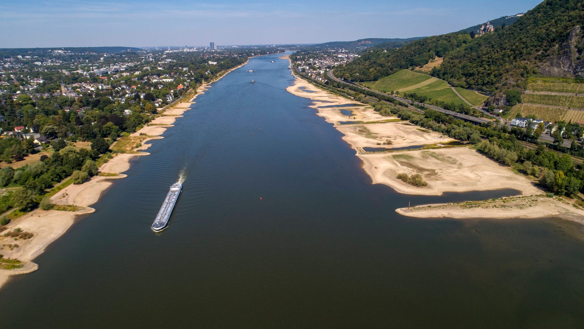 Wo der Rhein sonst zwischen grünen Ufern durch Deutschland fließt, gibt es seit einigen Wochen neue Sandstrände. Auf der Höhe von Bad Honnef hat die fortdauernde Trockenheit das Fundament des alten römischen Hafens freigelegt.