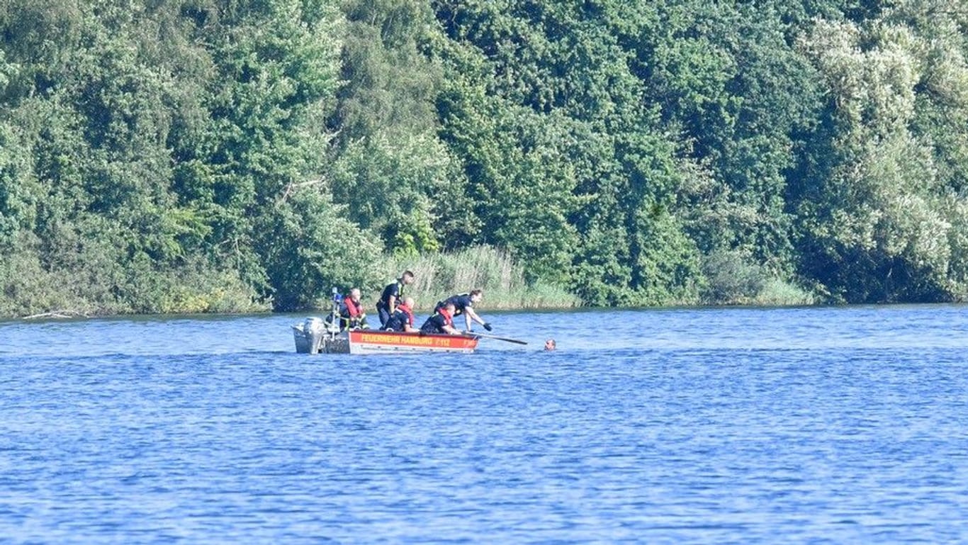 Festnahme auf dem Wasser: Einsatzkräfte von Polizei und Feuerwehr fischen den Tatverdächtigen aus dem See im Öjendorfer Park.