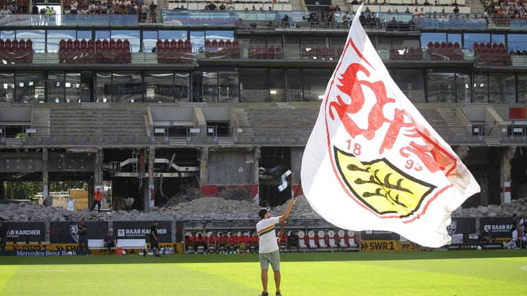 Vor dem Spiel gegen Lepizig schwenkt ein VfB-Mitarbeiter eine riesige VfB-Fahne: Im Hintergrund ist die Baustelle an der Haupttribüne der Stuttgarter Mercedes-Benz Arena zu sehen.