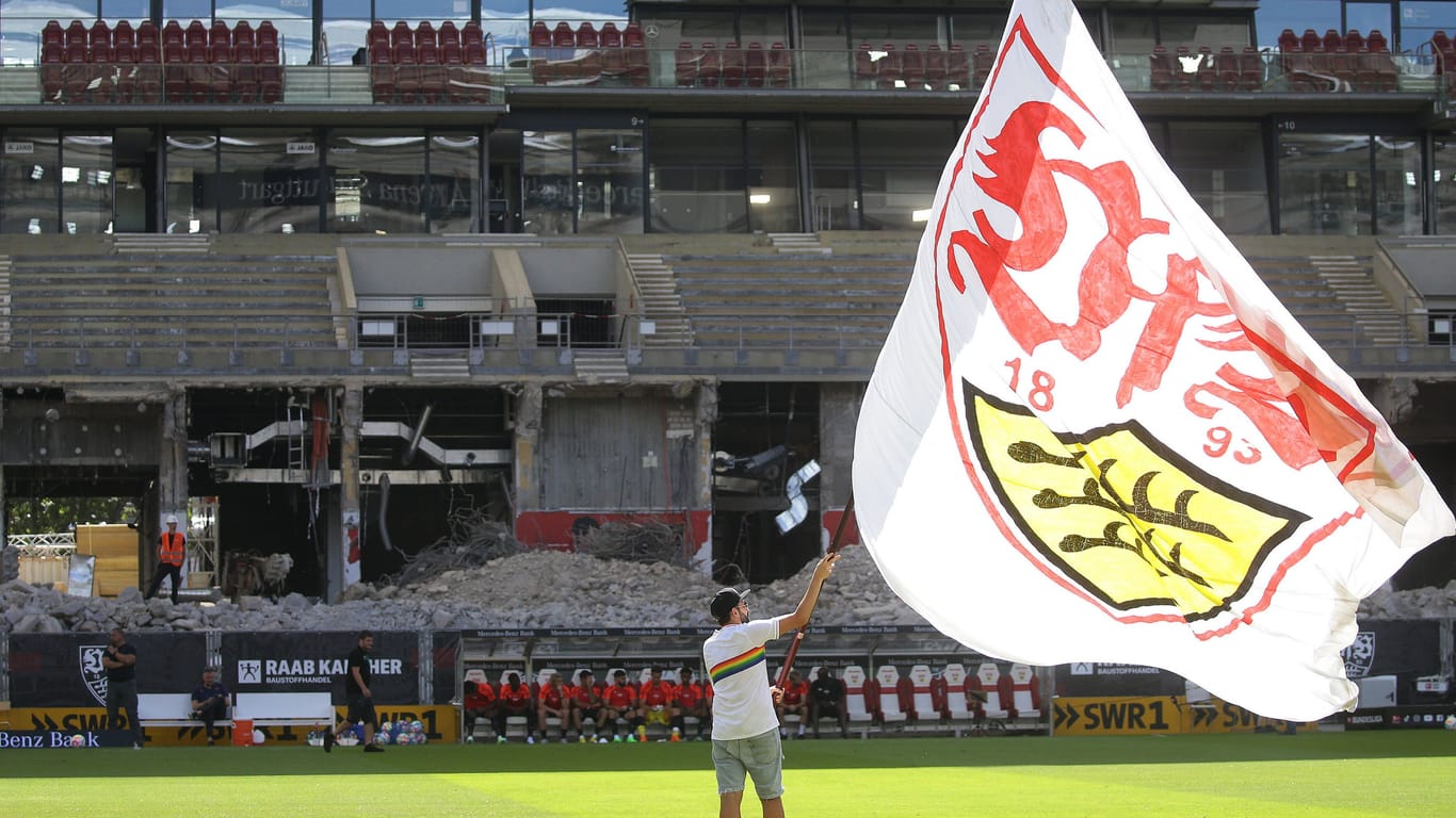 Vor dem Spiel gegen Lepizig schwenkt ein VfB-Mitarbeiter eine riesige VfB-Fahne: Im Hintergrund ist die Baustelle an der Haupttribüne der Stuttgarter Mercedes-Benz Arena zu sehen.