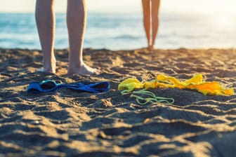 Frauen- und Männerfüße im Sand