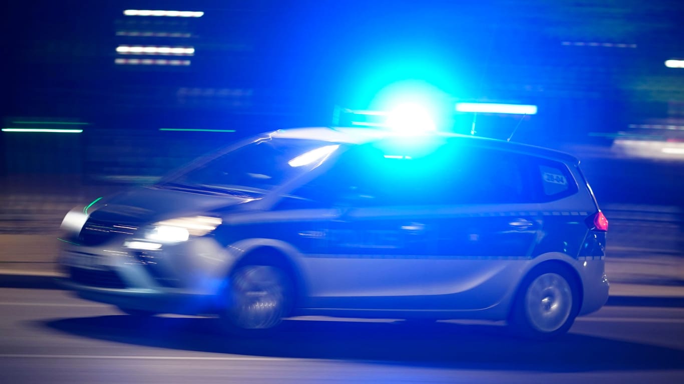 Ein Polizeiauto bei einer Einsatzfahrt mit Blaulicht (Symbolbild): Die Angreifer sollen wahllos auf Menschen eingeschlagen haben.