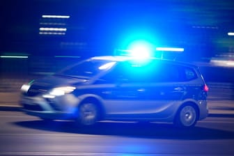 Ein Polizeiauto bei einer Einsatzfahrt mit Blaulicht (Symbolbild): Die Angreifer sollen wahllos auf Menschen eingeschlagen haben.