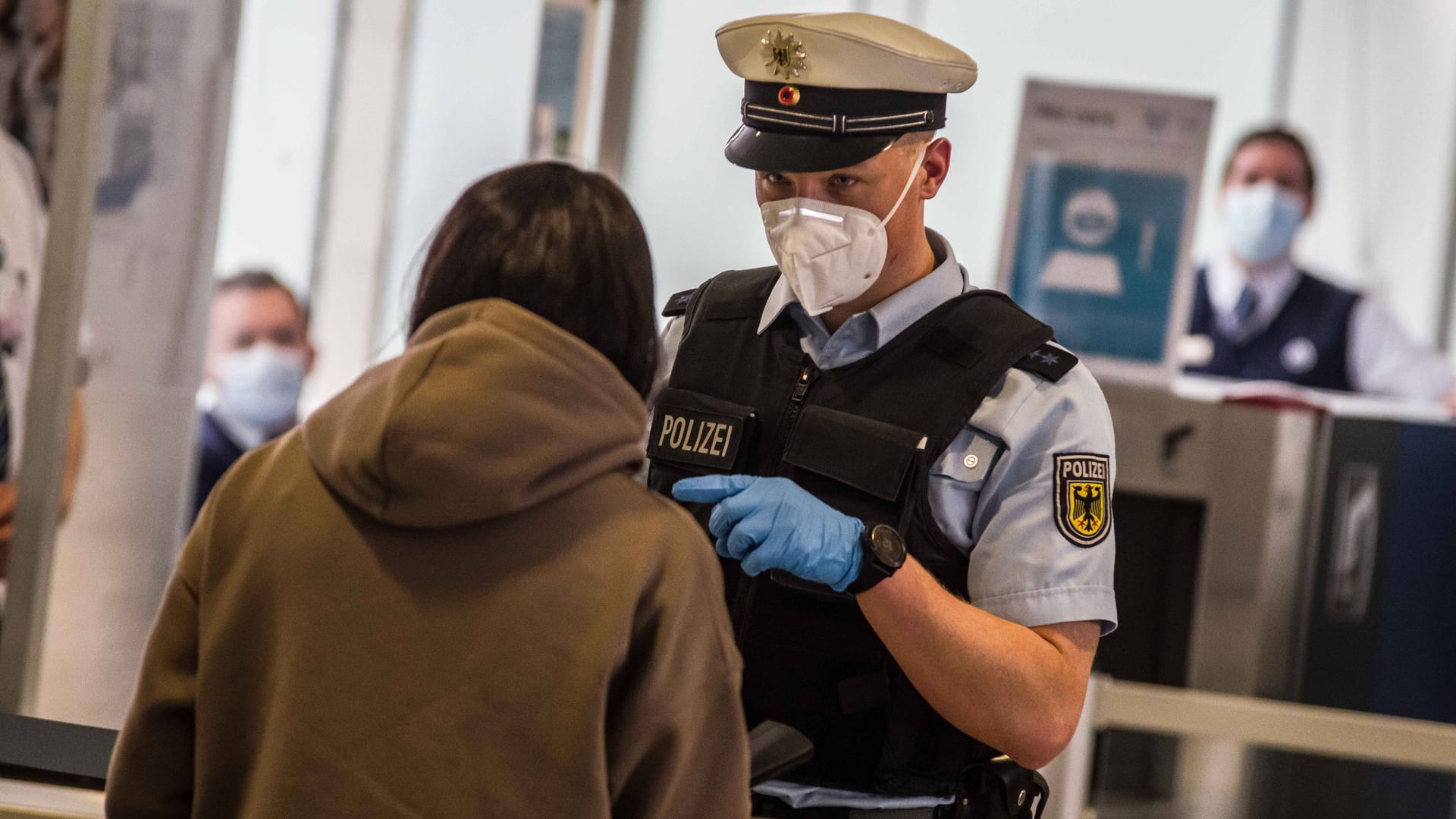 Ein Bundespolizist überprüft eine Reisende (Symbolbild): Am Sonntag kam es im Münchner Flughafen zu einem Polizeieinsatz.