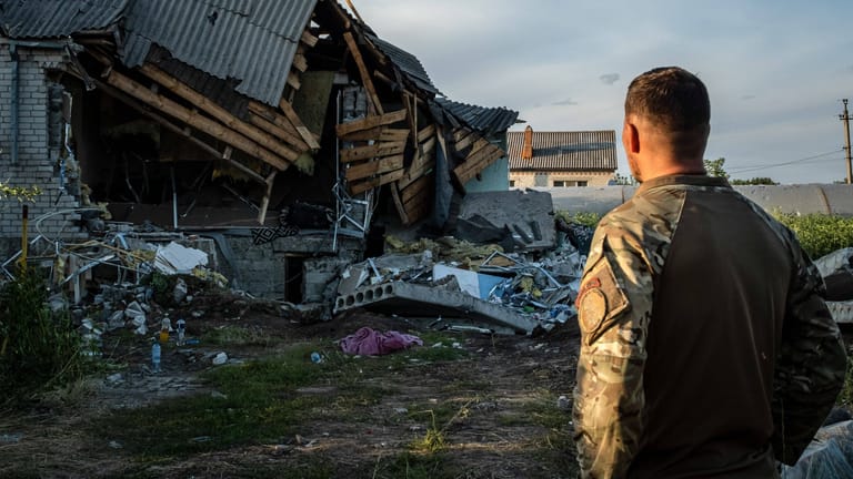 Ein ukrainischer Soldat steht vor Trümmern eines Hauses (Archivbild): Präsident Selenskyj spricht von vielen Opfern im Donbass.