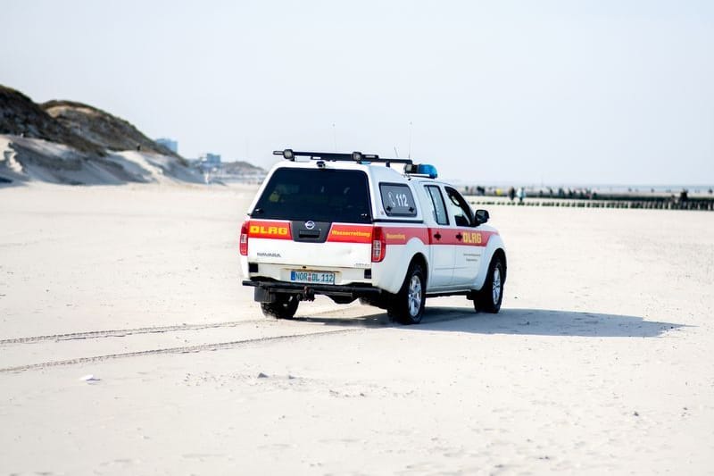 Ein Einsatzfahrzeug der DLRG Wasserrettung fährt über einen Strand (Symbolfoto): Zahlreiche Einsatzkräfte waren an der Suche beteiligt.