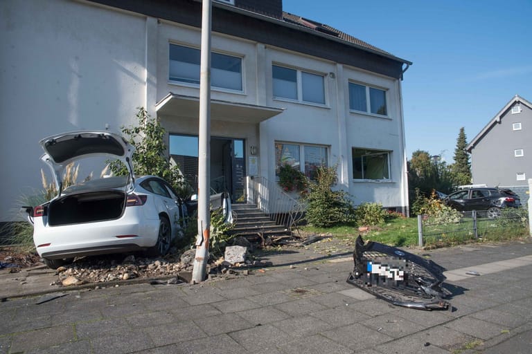 Der Tesla steht vor dem Hauseingang: Das Fahrzeug war zuvor gegen geparkte Autos gekracht.