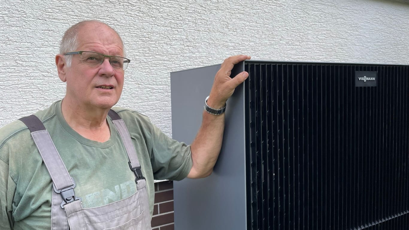 Henning Kellner mit seiner neuen Wärmepumpe. Das Gerät steht unter dem Küchenfenster, es arbeitet jedoch sehr leise und ist im Haus kaum zu hören.
