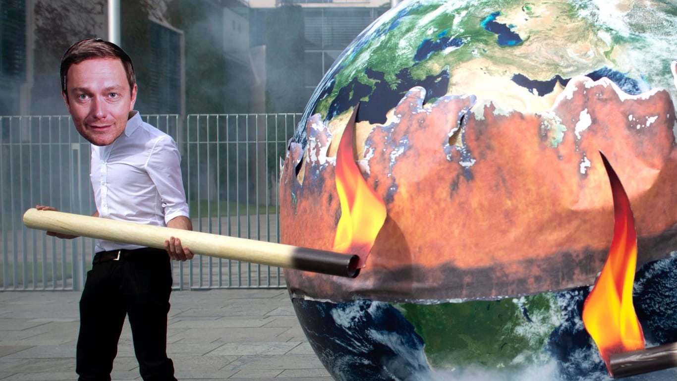 Klima Protest vor dem Bundeskanzleramt: Demonstranten zeigen sich mit einer brennenden Weltkugel und Masken von Bundesfinanzminister Christian Lindner und Bundesverkehrsminister Volker Wissing.