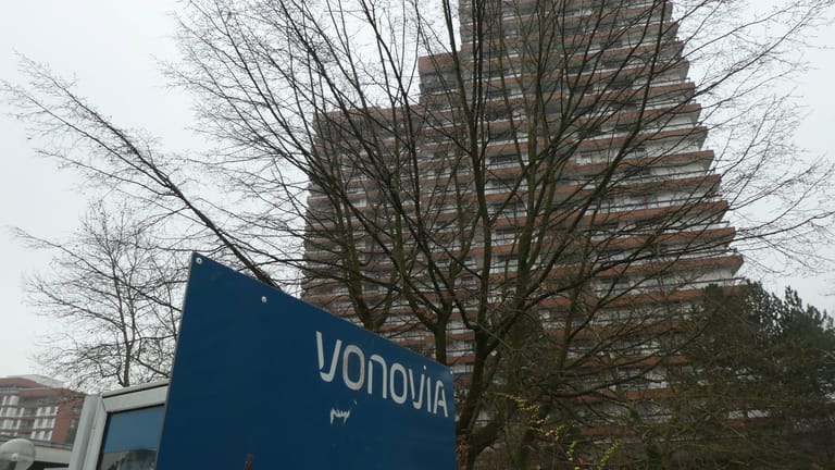 Logo des Immobilienkonzerns Vonovia vor Wohngebäude: Wenn die Summe, die der Mieter schuldet, zwei Monatsmieten beträgt, kann es zur Kündigung kommen.