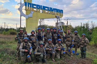 Ukrainische Soldaten vor dem Ortsschild einer befreiten Stadt: Kiew macht derzeit Fortschritte bei der Rückeroberung.