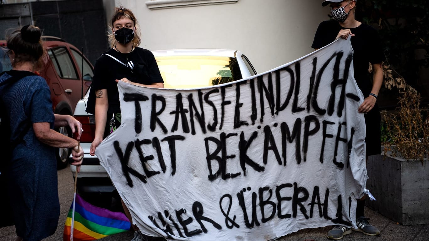 "Transfeindlichkeit bekämpfen, Hier & Überall" steht auf einem Plakat von Teilnehmer einer Mahnwache in Bremen. (Archivbild)