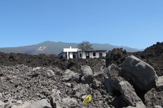 Ein beschädigtes Wohnhaus in der erkalteten Lava auf La Palma: Auch ein Jahr nach dem Vulkanausbruch hat die Urlaubsinsel noch viele Probleme.