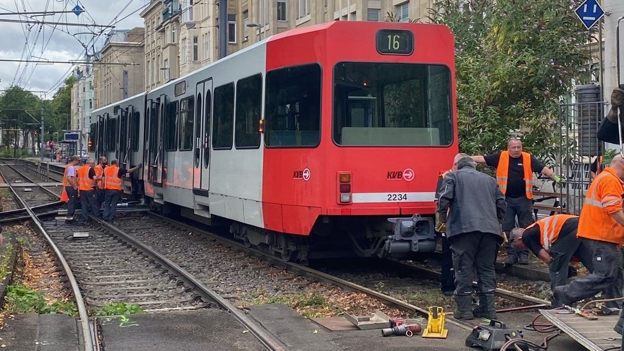 Mitarbeiter der KVB versuchen, die entgleiste Stadtbahn wieder auf die Gleise zu setzen.