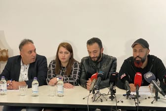 Ferat Kocak (r, Die Linke) sitzt neben einem Ehepaar aus Syrien und dessen Dolmetscher (l) bei einer Pressekonferenz der Linkspartei.