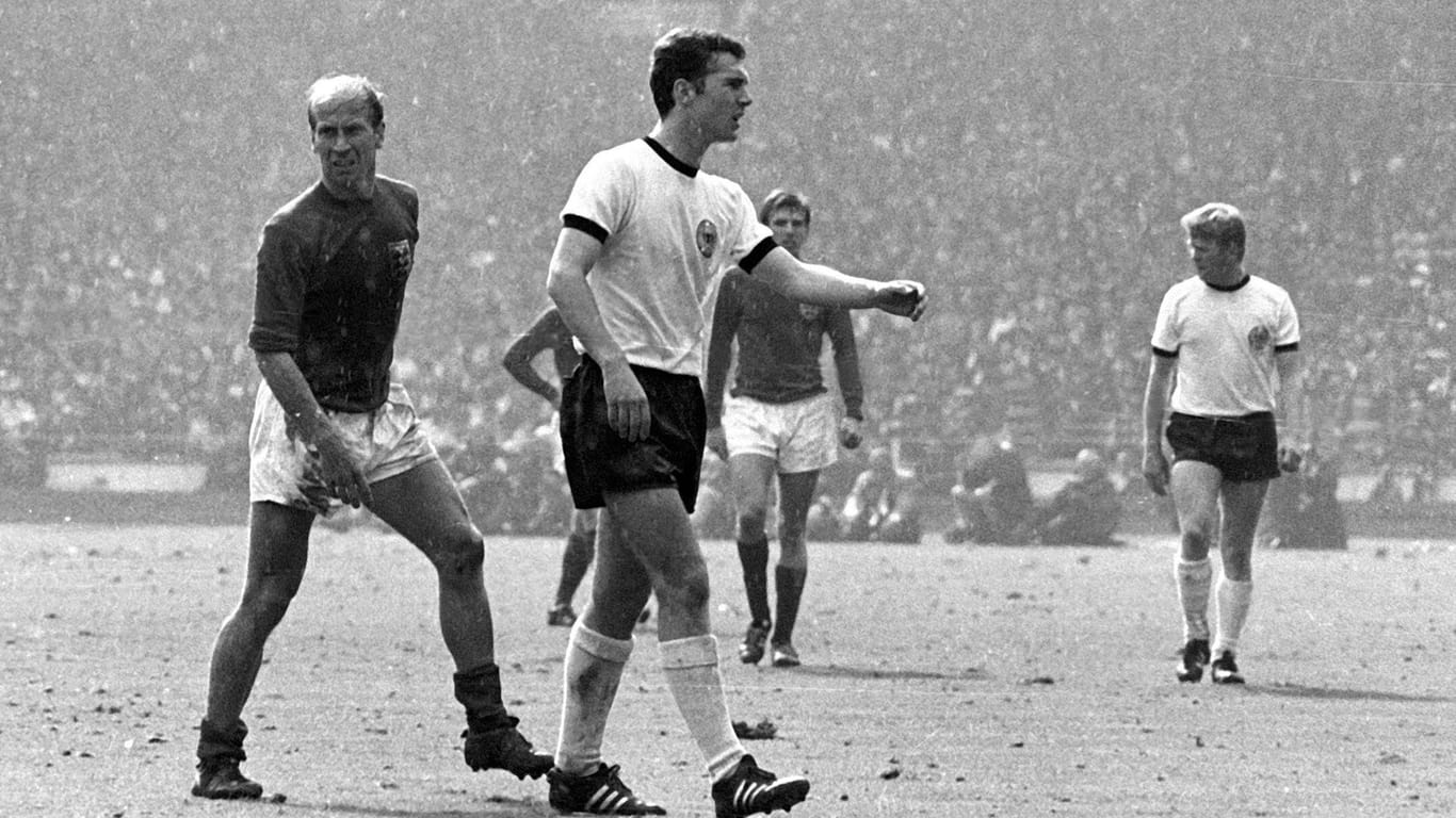 Bei der WM 1966 in England geht Beckenbauers Stern auf. Als defensiver Mittelfeldspieler erzielt er insgesamt vier Tore und belegt den dritten Platz in der Torschützenliste. Im Endspiel gegen England ist er der Sonderbewacher des damaligen Superstars Bobby Charlton (l.). Hinterher stellt sich heraus, dass Charlton wiederum den Auftrag hatte, Beckenbauer zu bewachen. Beide neutralisieren sich.