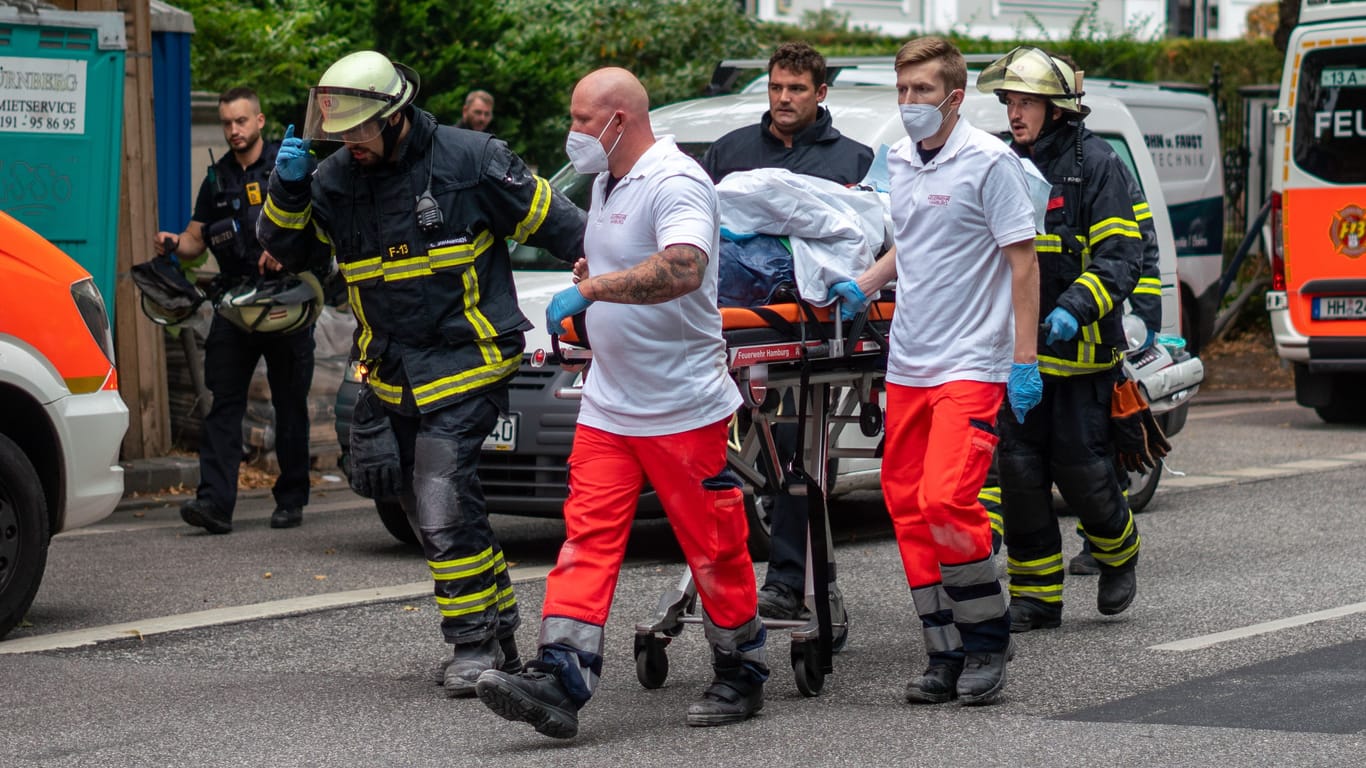 Die Rettungskräfte bringen den Verletzten ins Krankenhaus: Er wurde unter einem Baugerüst eingeklemmt.