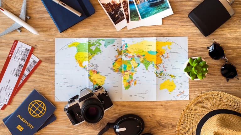 Weltkarte und Reiseutensilien: Erkennen Sie alle Sehenswürdigkeiten?