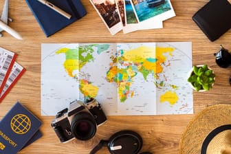 Weltkarte und Reiseutensilien: Kniffliges Erdkunde-Quiz – Wissen Sie, wie weit diese Orte voneinander entfernt liegen?