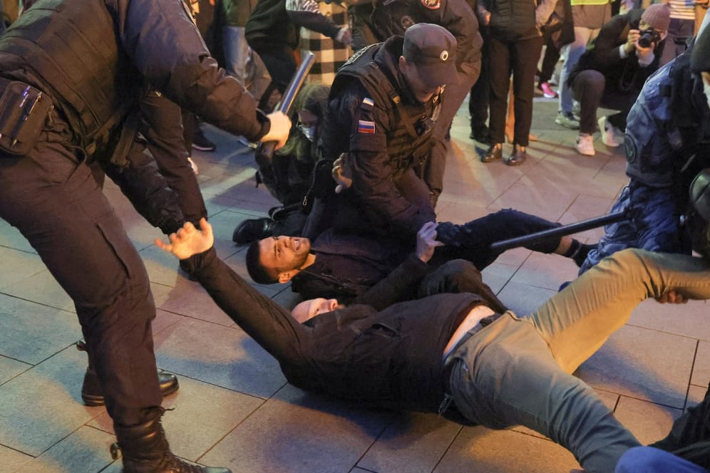 Russian police officers detain men during an unsanctioned rally in Moscow