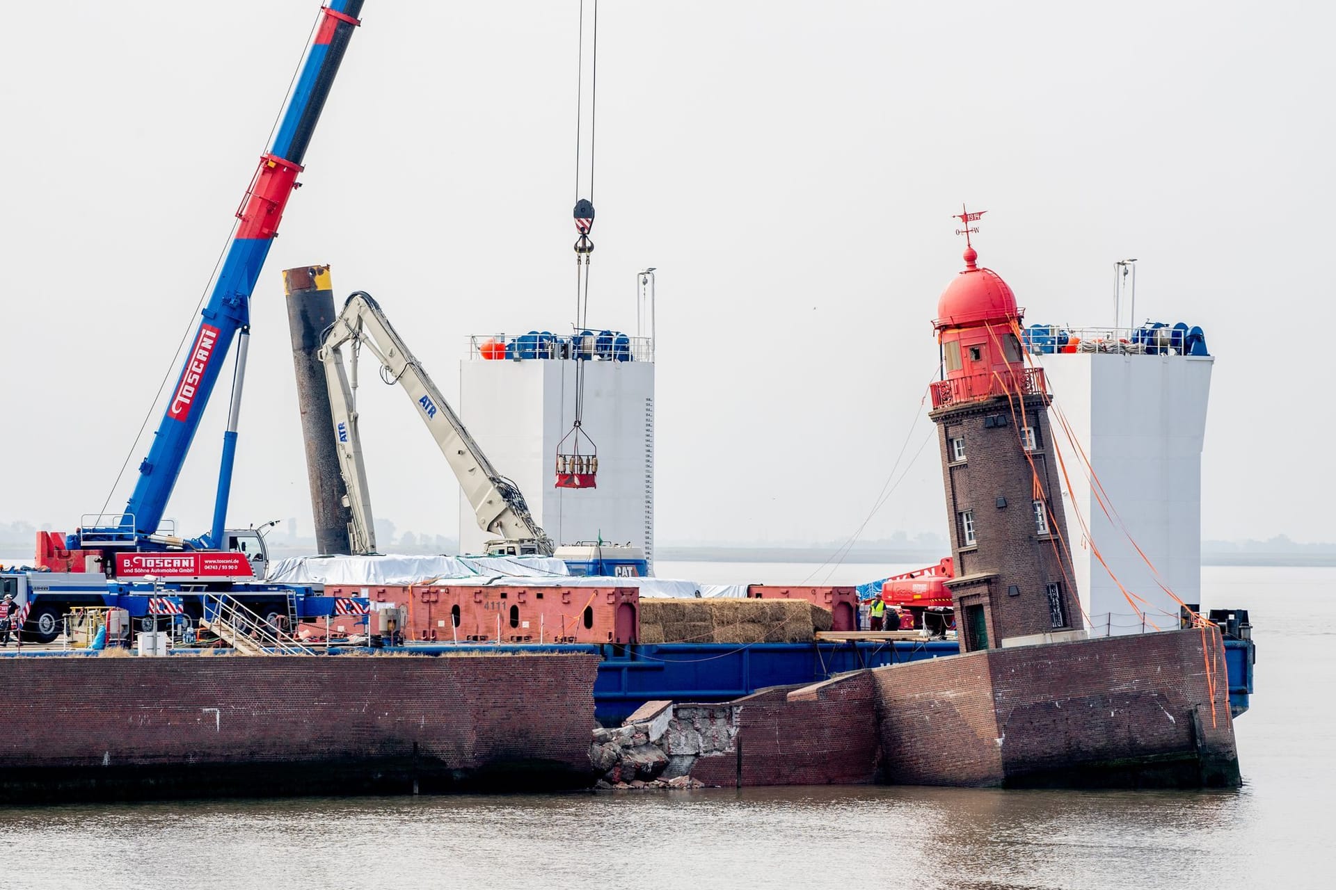 Der Leuchtturm auf der Nordmole in Bremerhaven ist bereits abgebaut. Am Montag startete der Abriss der Molenwand, nun sind Teiler dieser eingestürzt.