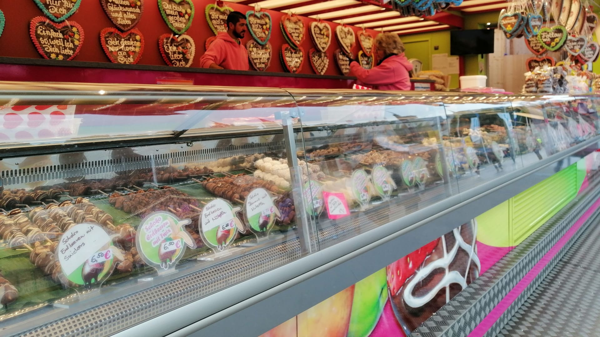 Lebkuchenherzen, Schokofrüchte und andere Süßigkeiten in einem Stand auf dem Oktoberfest. Nicht nur deftiges, auch Desserts gehören zum Oktoberfest zwischen zwei Bieren dazu.