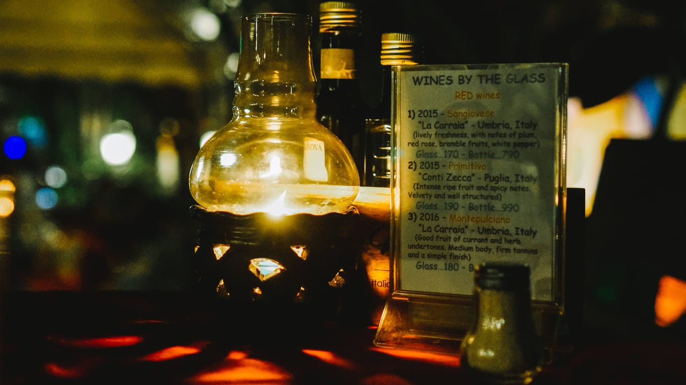 Eine Öl-Kerze auf einem Tisch in einer Bar (Symbolbild): Einen Abend in der Woche will die Bar gang ohne Strom auskommen.