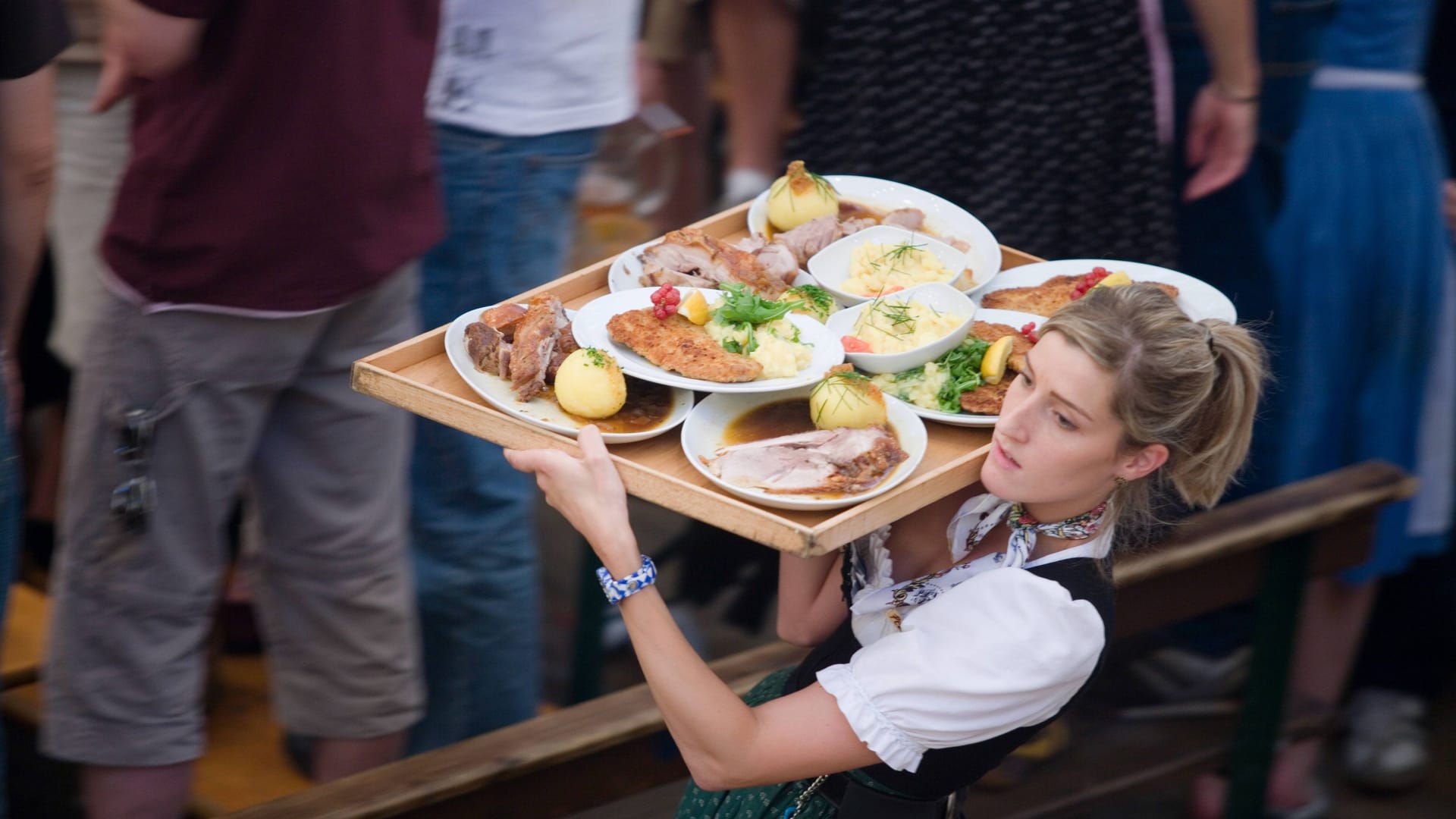Kellnerin mit Essen auf der Wiesn (Symbolbild): Für Speis und Trank muss zuweilen tief in die Tasche gegriffen werden.