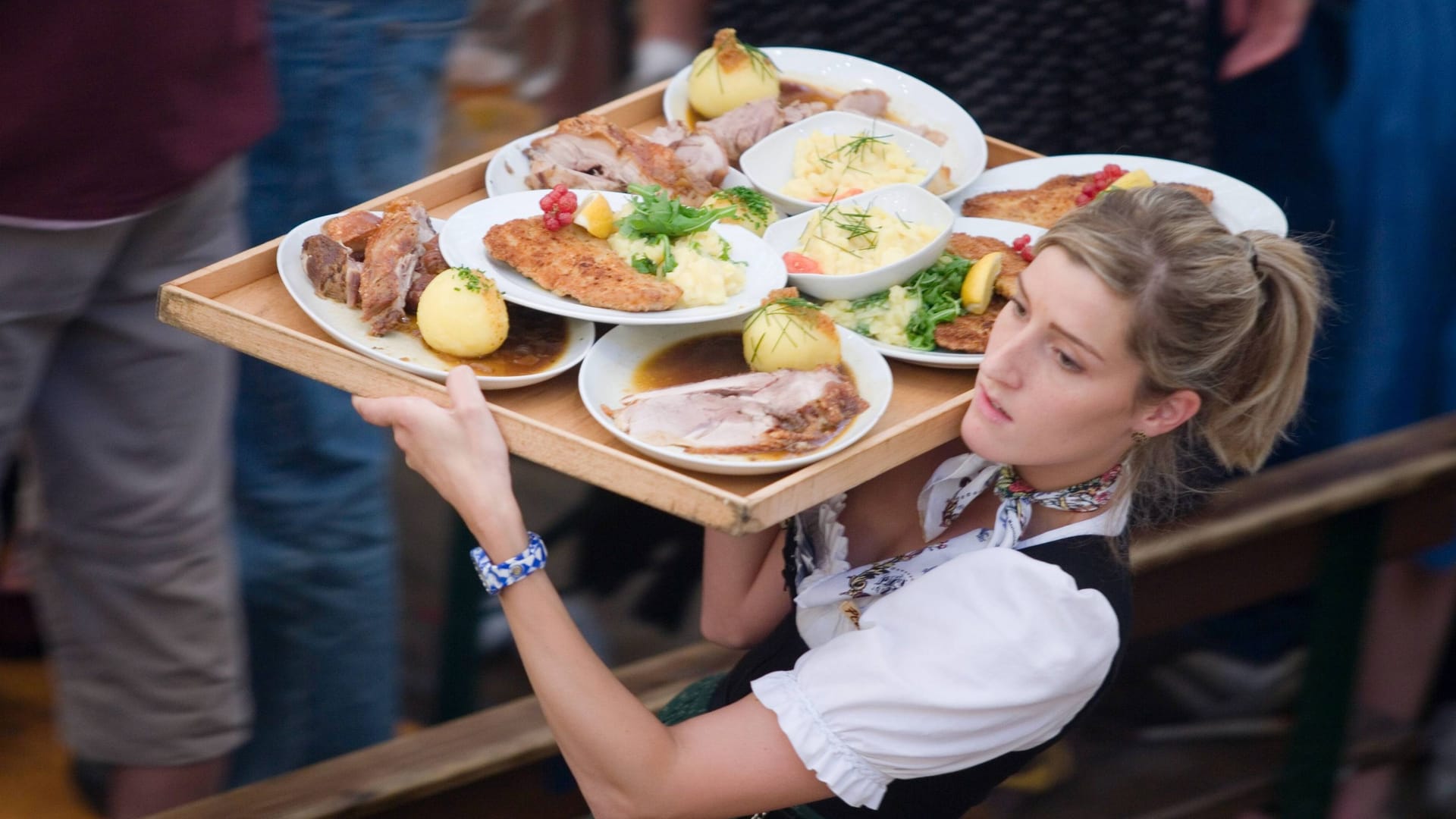 Kellnerin mit Essen auf der Wiesn (Symbolbild): Für Speis und Trank muss zuweilen tief in die Tasche gegriffen werden.