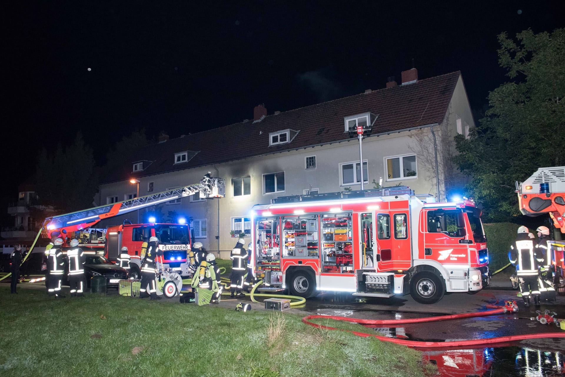 Löschfahrzeuge stehen vor dem Wohnhaus: Ein Bewohner wurde von der Feuerwehr aus dem Haus gebracht.