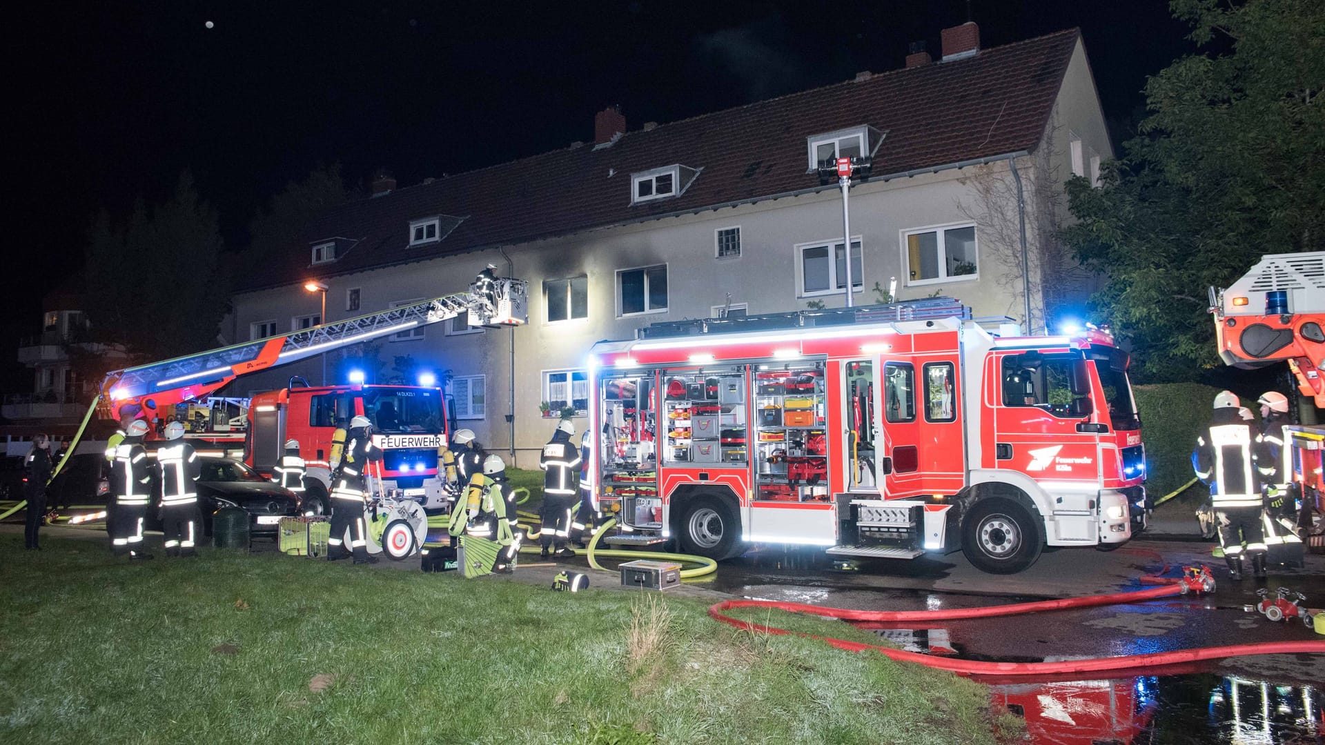 Löschfahrzeuge stehen vor dem Wohnhaus: Ein Bewohner wurde von der Feuerwehr aus dem Haus gebracht.