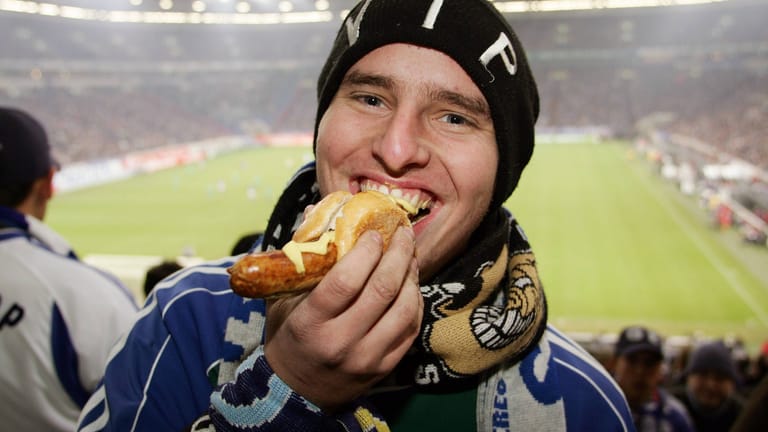 Ein Schalke-Fan beißt in seine Stadionwurst: Die Arena auf Schalke kann aber auch vegan.