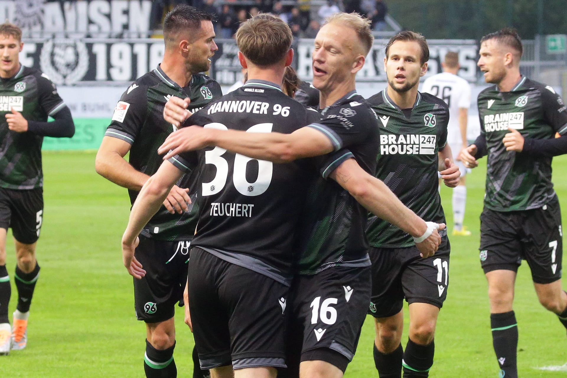 Hannovers Teuchert (M.) und Nielsen jubeln im Spiel in Sandhausen.