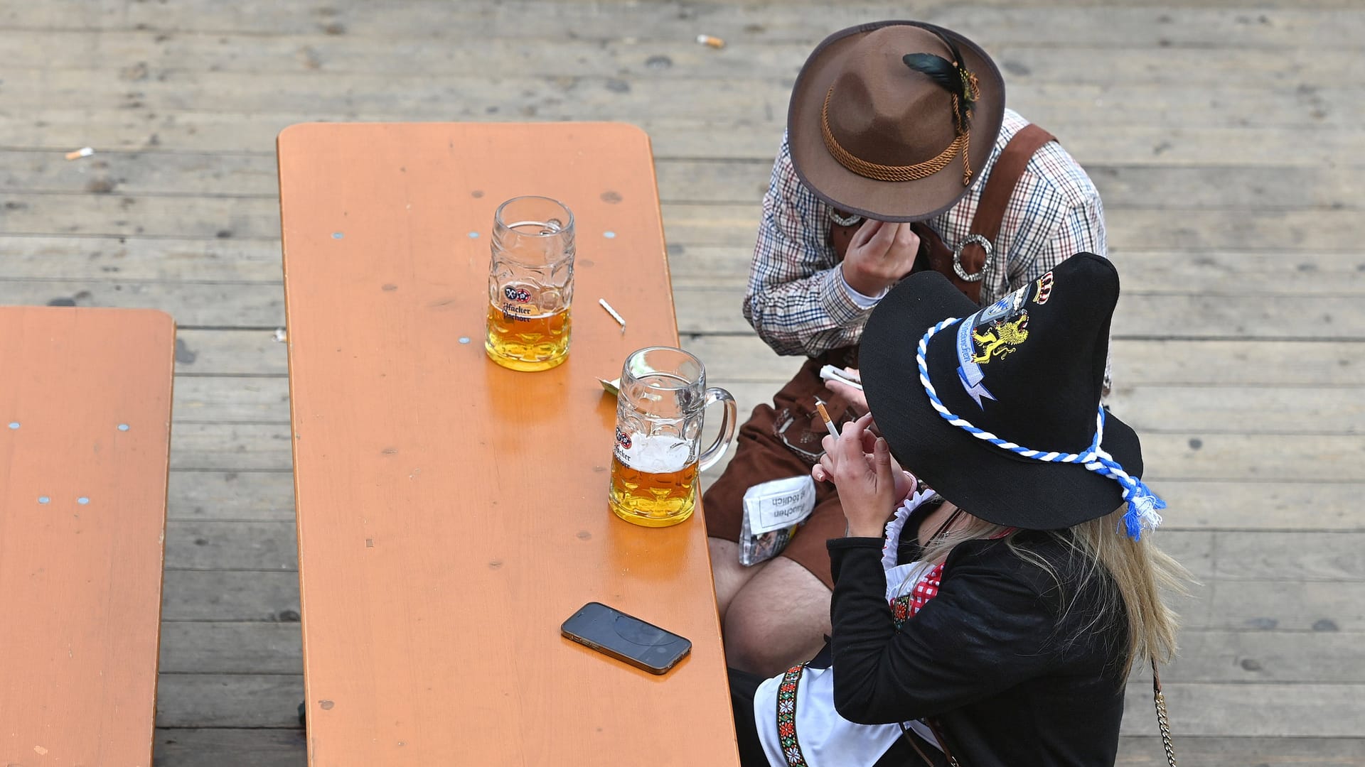 Zwei gelangweilte Gäste auf dem Oktoberfest 2022 (Archivbild): Ist heuer weniger los als auf den vorherigen Oktoberfesten?