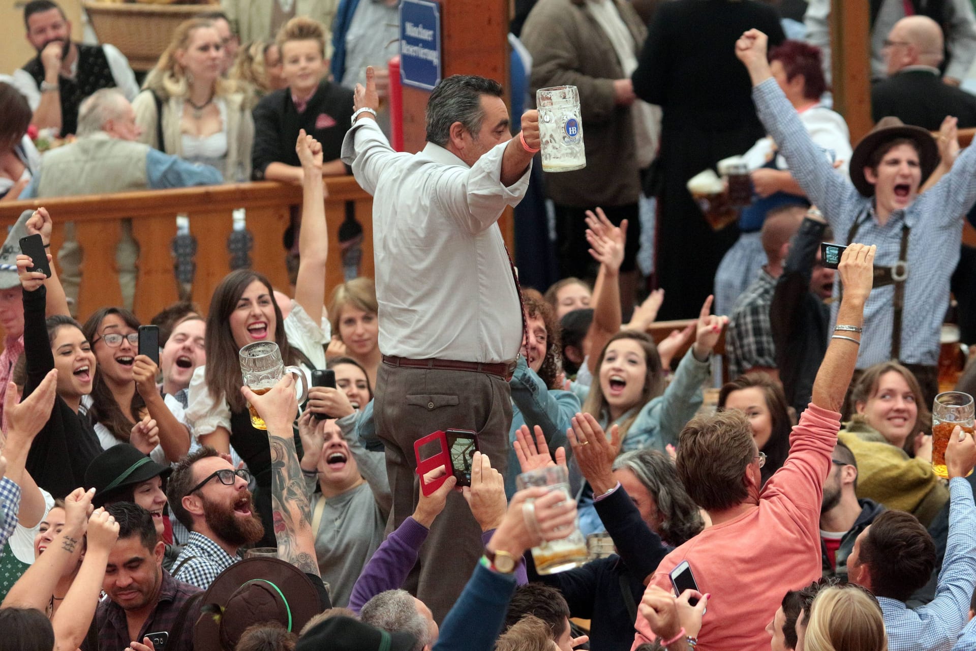 Eng an eng drängen sich die Wiesn-Besucherinnen und -Besucher im Bierzelt: Vor wenigen Monaten wäre das undenkbar gewesen.