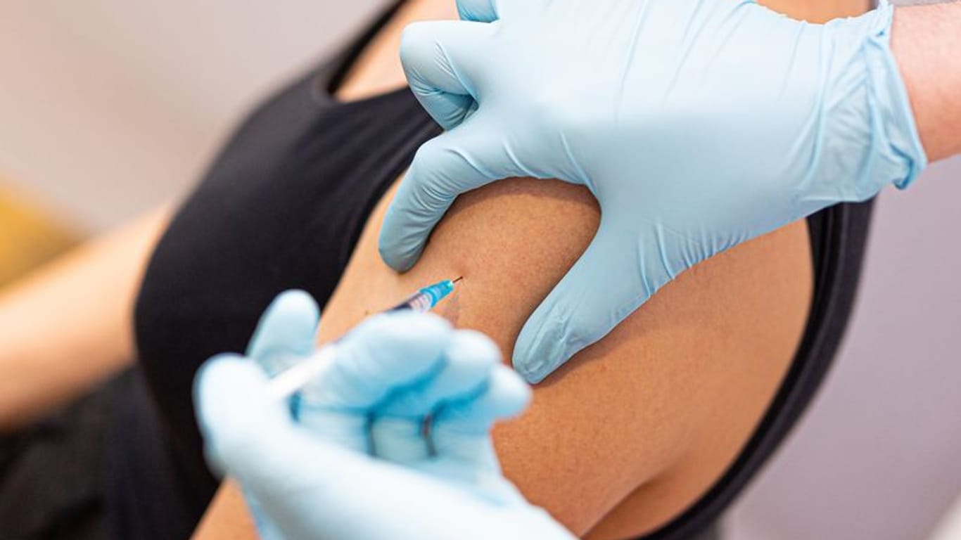 Eine Ärztin impft eine Frau gegen Corona (Symbolfoto): Der Andrang für den angepassten Impfstoff ist aktuell überschaubar.