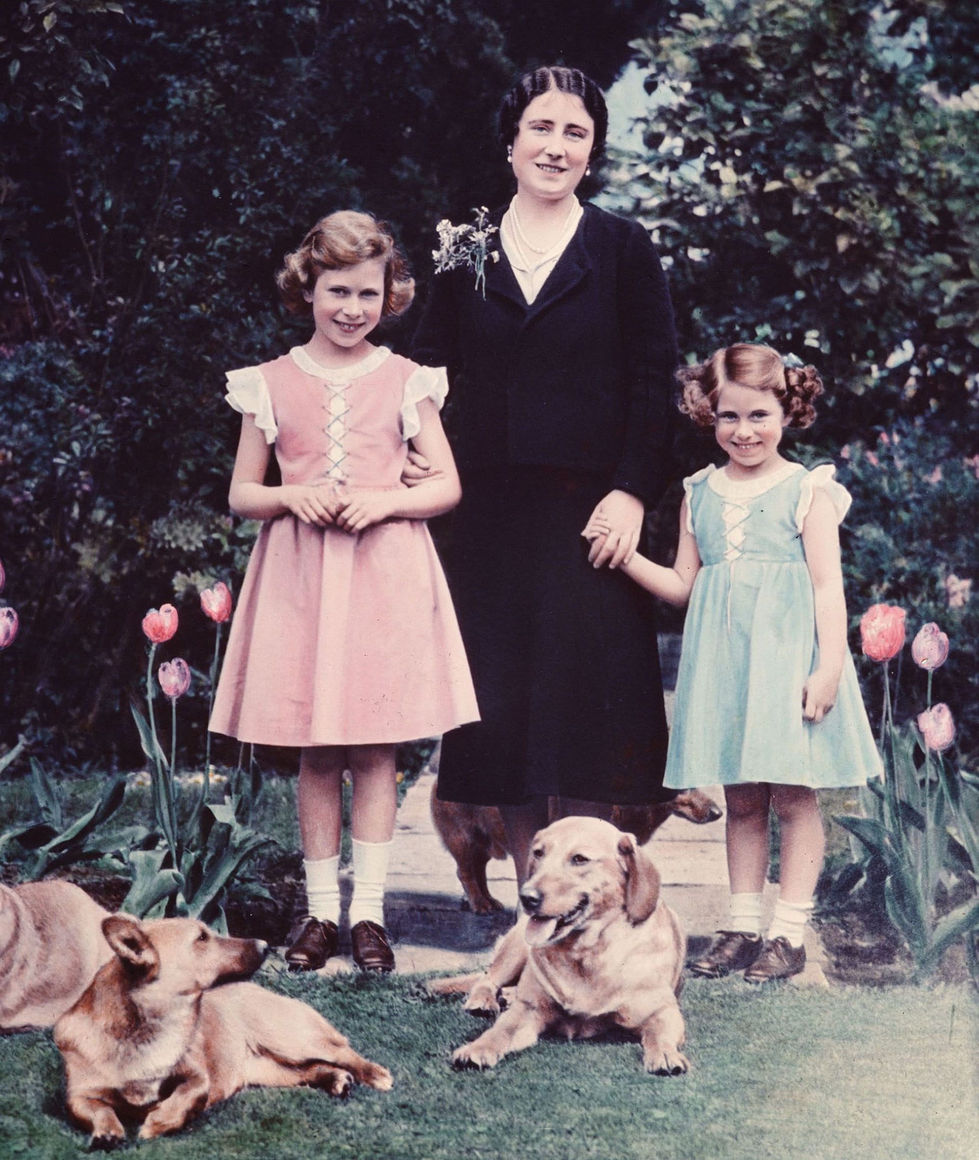 Juli 1936: Prinzessin Elizabeth (links) mit ihrer Mutter Elizabeth und ihrer jüngeren Schwester Margaret im Garten von Schloss Windsor.