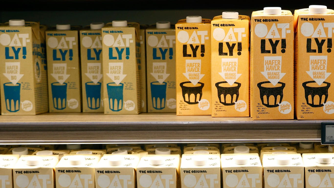 Milchersatzgetränke von Oatly in einem Düsseldorfer Supermarkt: Im Gegensatz zu Kuhmilch müssen ungeöffnete Pflanzendrinks nicht ins Kühlregal. Trotzdem stehen sie oft dort - hier fällt die Wahl zwischen Original und Alternative.