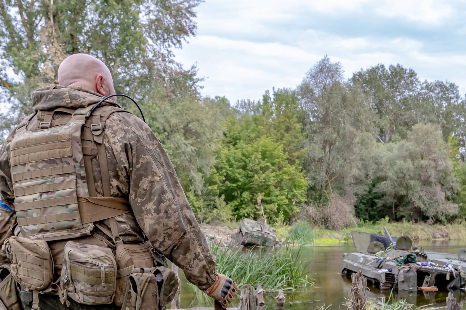 Ein ukrainischer Soldat blickt auf zerstörte russische Panzer im Siwerski-Donez-Fluss.