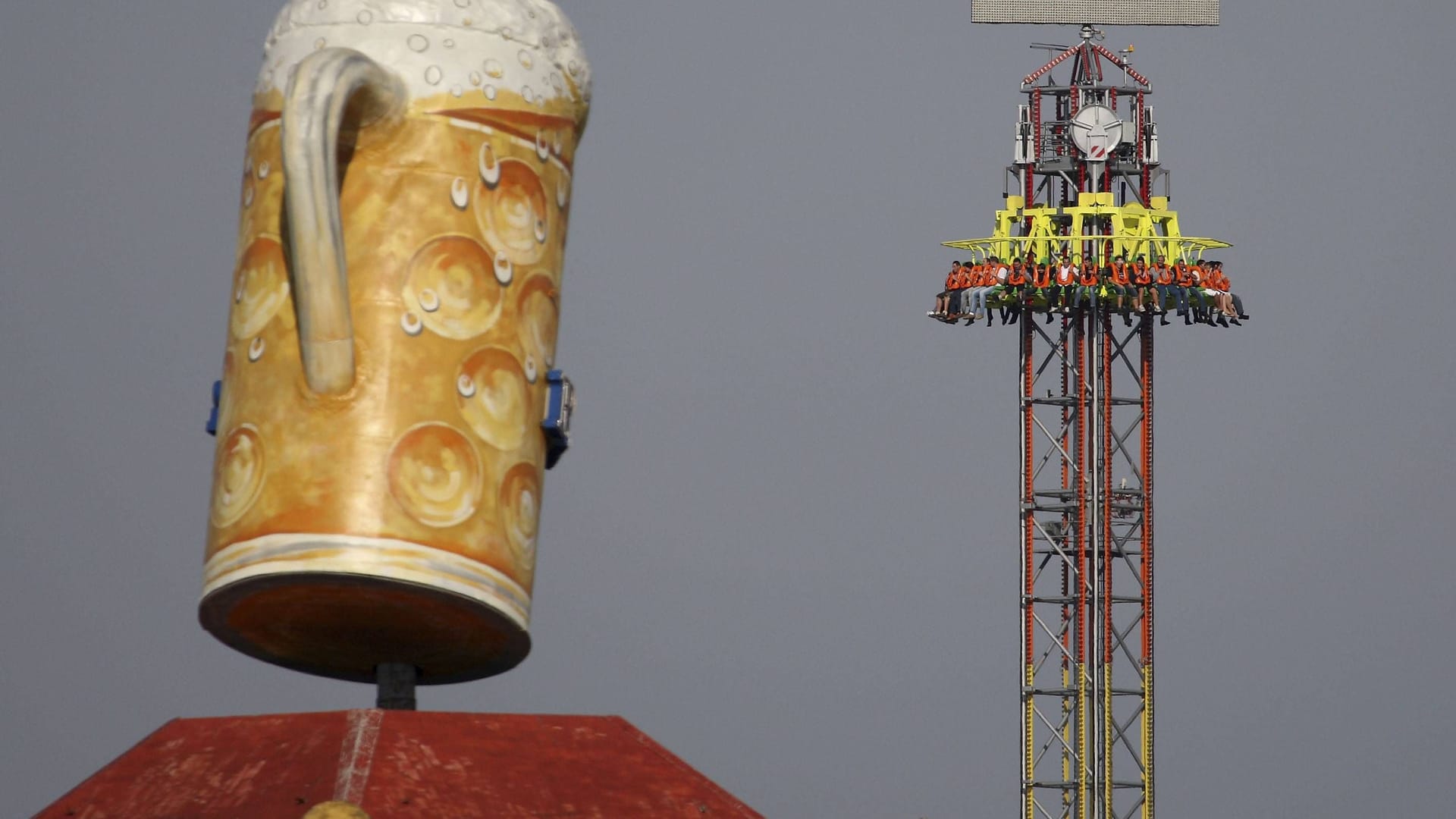 Biergläser gehören zum Oktoberfest wie Fahrgeschäfte, etwa dem Freefall-Tower hier im Hintergrund (Archivbild): Für Menschen mit Höhenangst ist das aber nichts.