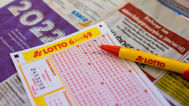 Ein Lottoschein und ein Kugelschreiber liegen in einer Annahmestelle auf dem Tresen (Symbolbild): Vom Gewinn will sich der Gewinner einen neuen Fernseher kaufen.