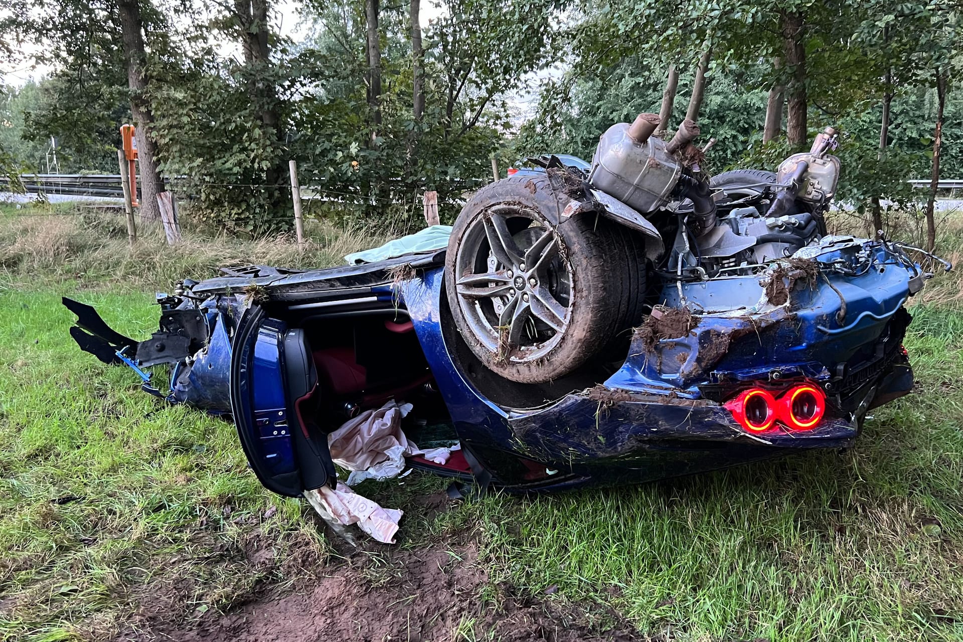 Der demolierte Ferrari liegt auf dem Dach neben der Autobahn: Beide Insassen wurden nur leicht verletzt.